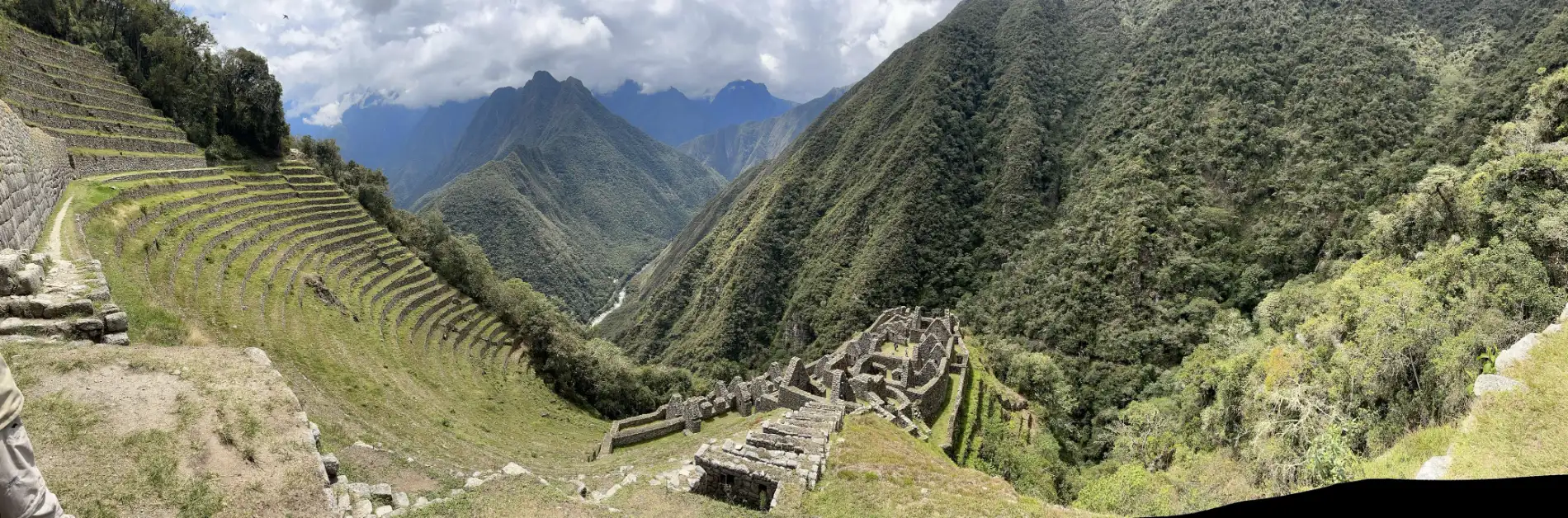 Panoramic view of the Wiñay Wayna Inca ruins on the Short Inca Trail, surrounded by lush green mountains in the Andes
