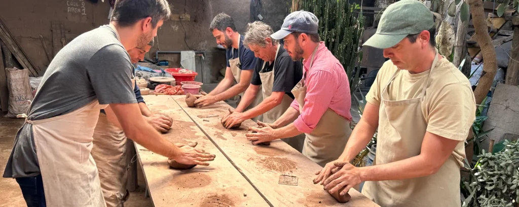 Travelers with Perú Increíble participating in an Andean pottery workshop in the Sacred Valley, shaping clay with local artisans