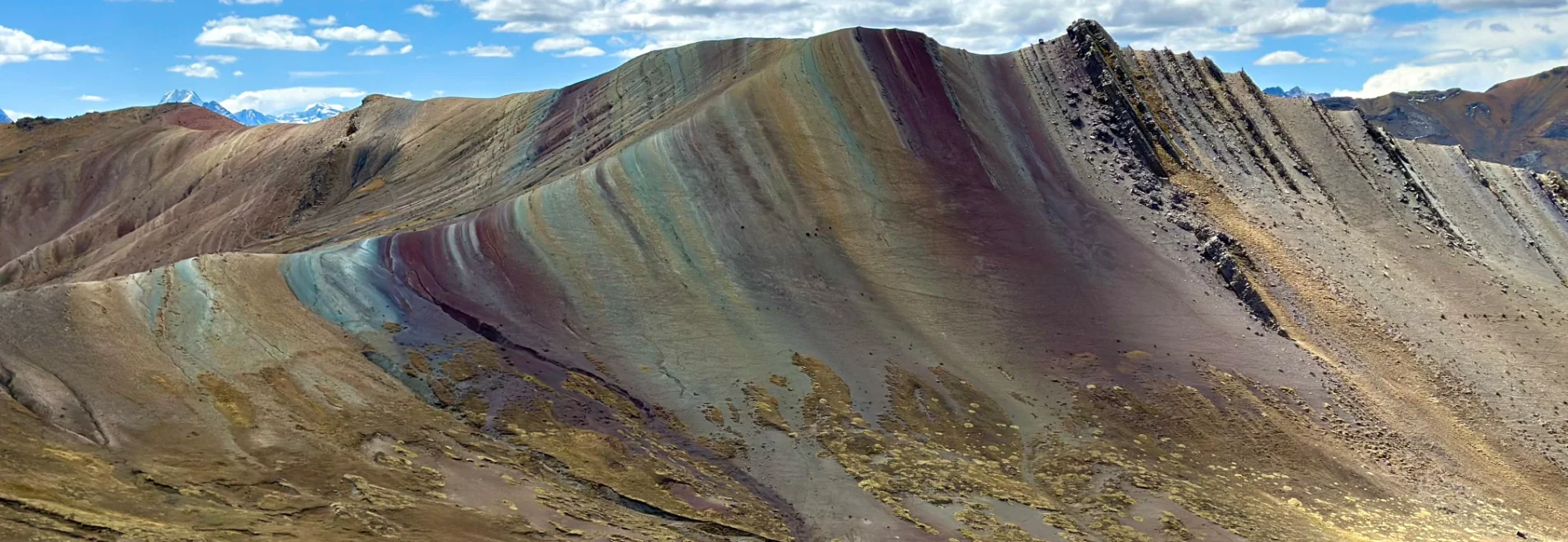 View of Palccoyo Mountain with colorful layered peaks and a clear sky in the Peruvian Andes