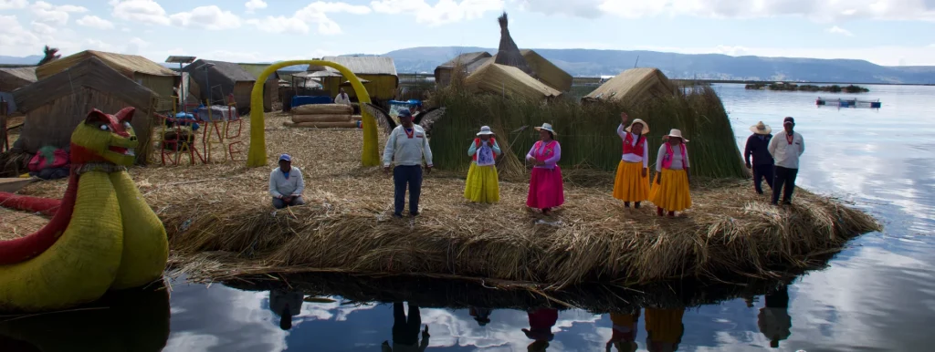 Scene of arriving at a Uros floating island on Lake Titicaca, with local people waiting to welcome visitors from the boat