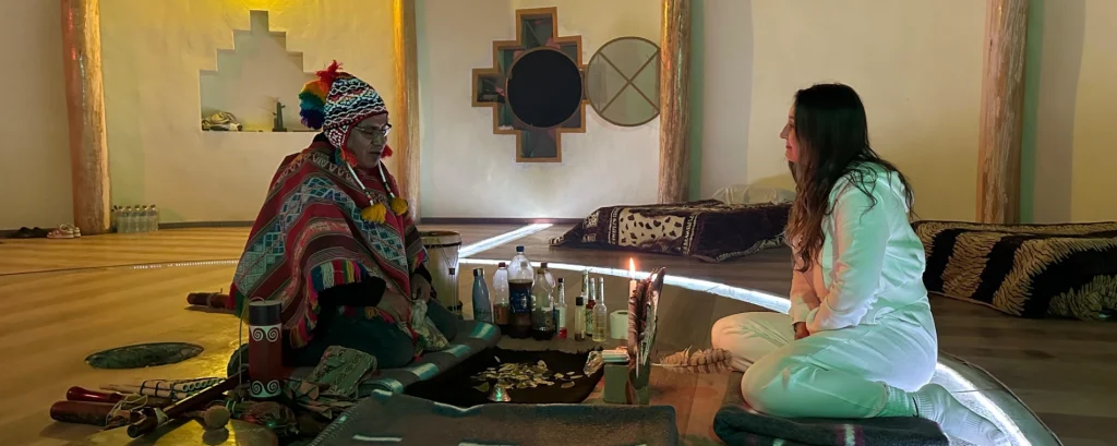 Client seated in a ceremonial temple preparing to drink ayahuasca during an Ayahuasca and Huachuma dieta retreat, sitting in front of the shaman.
