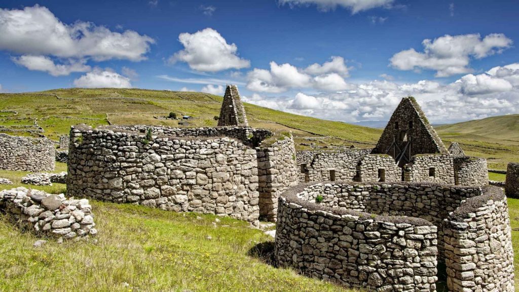Historic stone ruins and archaeological agricultural site under blue skies on a custom Peru cultural tour
